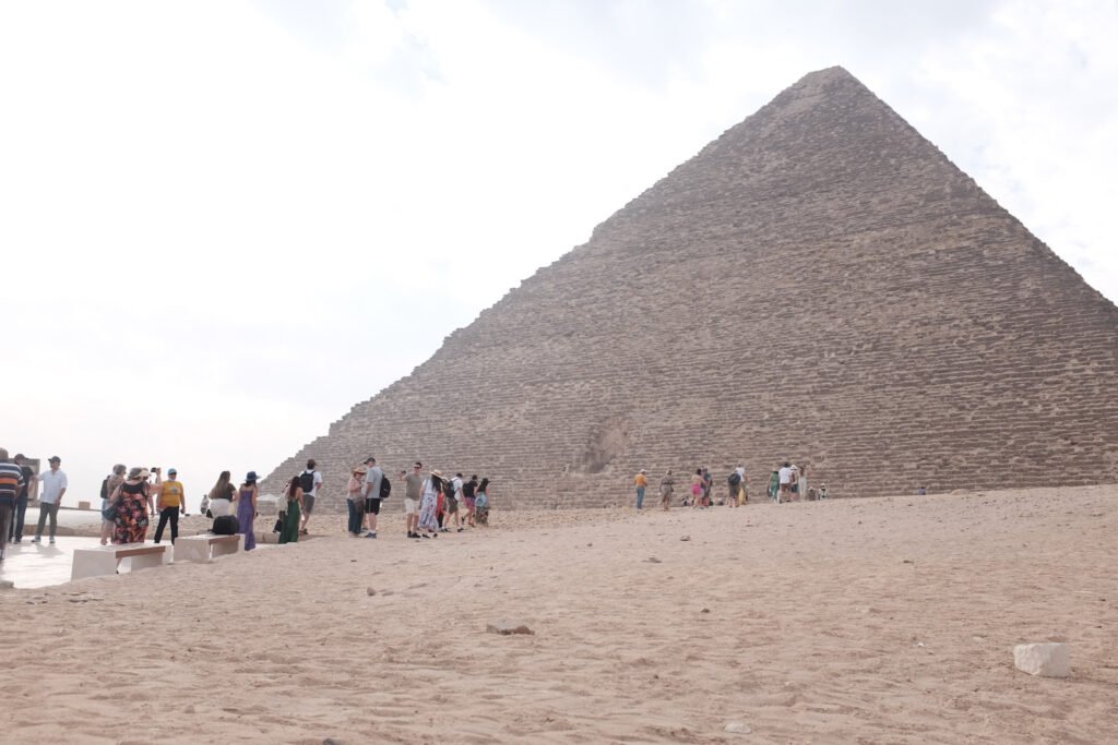 A flock of tourists enters the Giza Plateau with the Great Pyramid in sight.