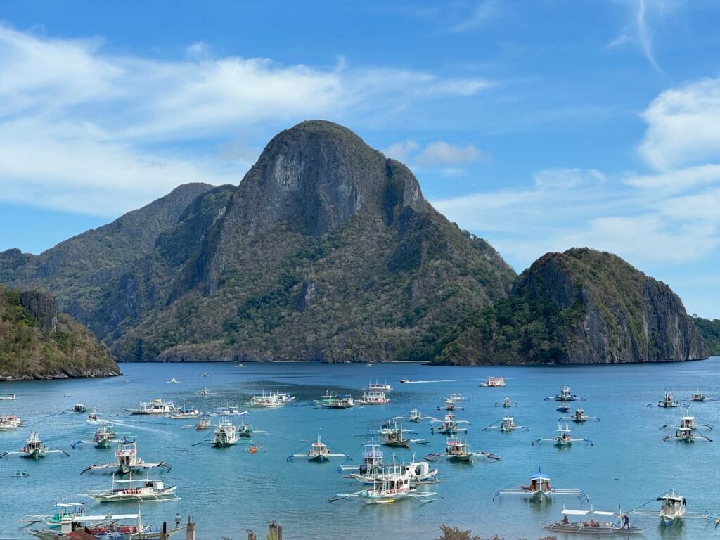 A view of Cadlao Island and several boats anchored in El Nido beach.