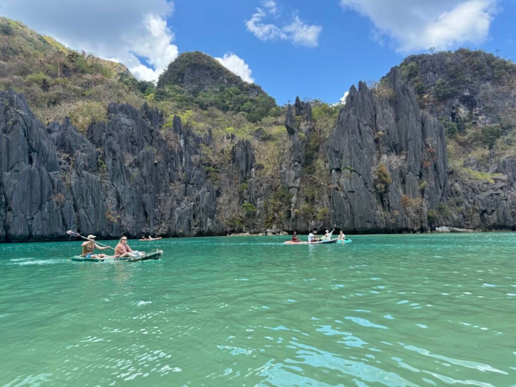 Tourists paddling their kayaks at Cadlao Lagoon in El Nido, Philippines.