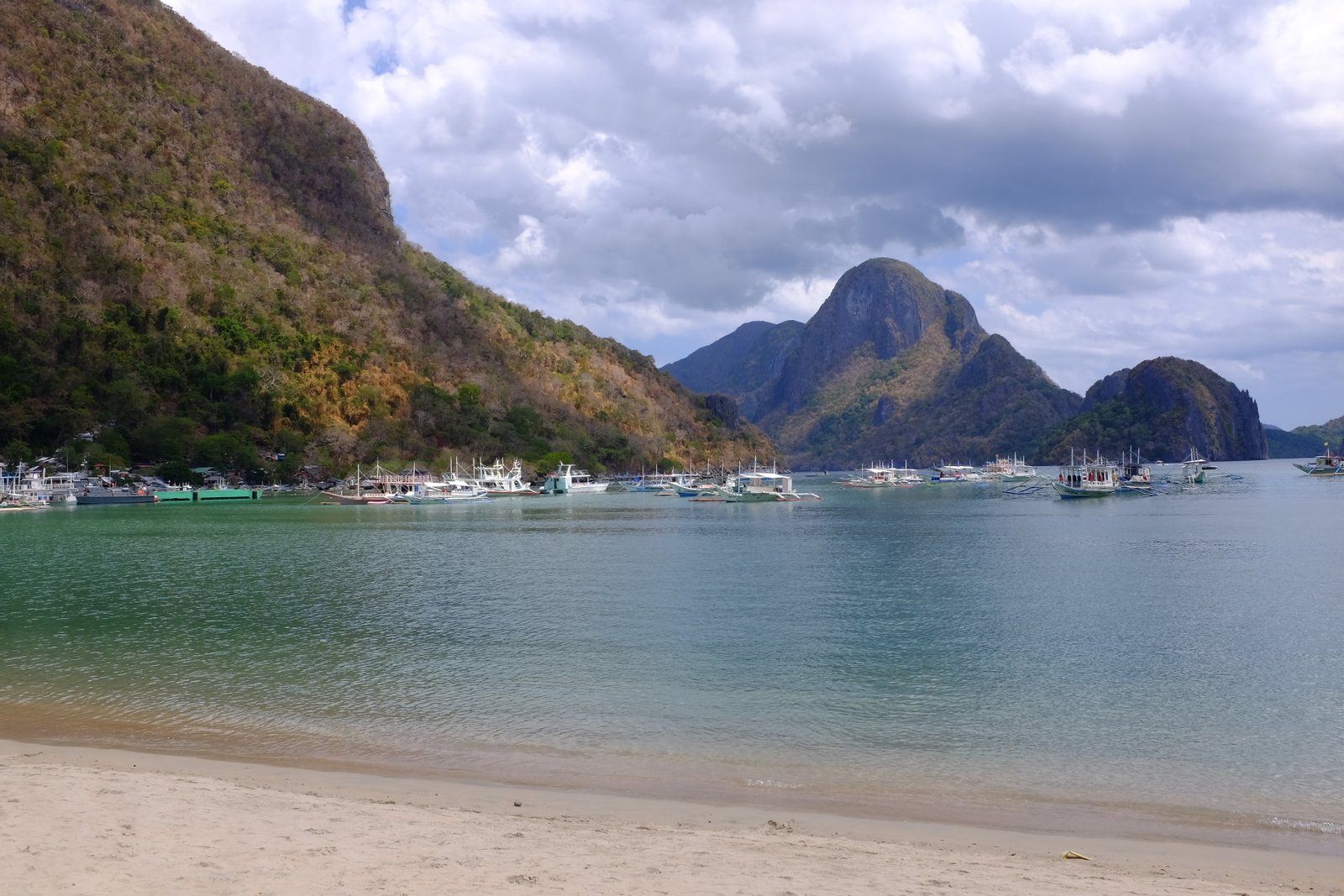 Several boats anchored at El Nido Beach in El Nido, Philippines.