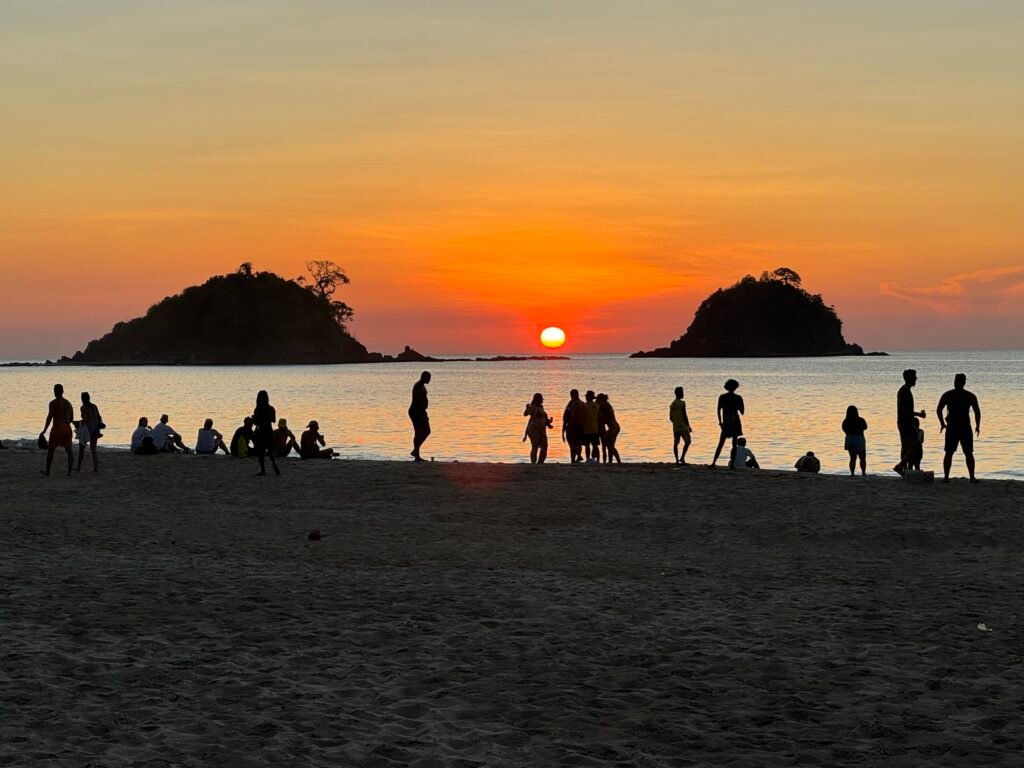 A group of people enjoying the sunset view at Nacpan Beach in El Nido, Philippines.