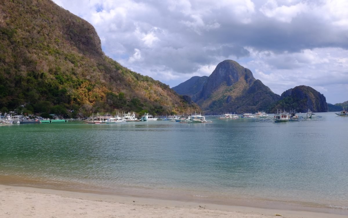 Several boats anchored at El Nido Beach in El Nido, Philippines.