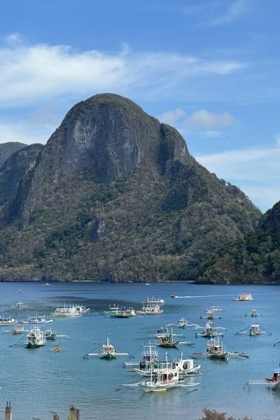 A view of Cadlao Island and several boats anchored in El Nido beach.