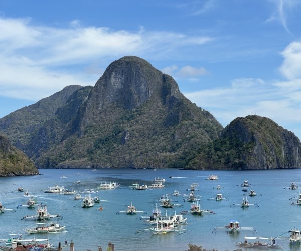 A view of Cadlao Island and several boats anchored in El Nido beach.