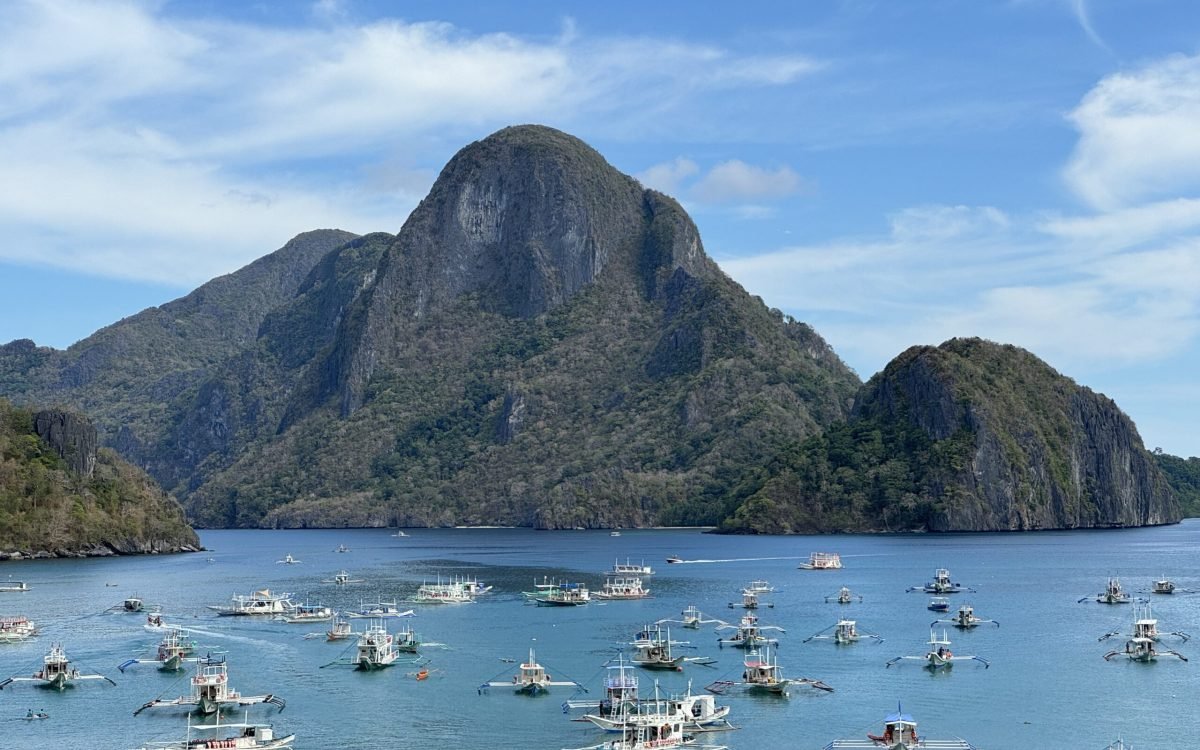 A view of Cadlao Island and several boats anchored in El Nido beach.